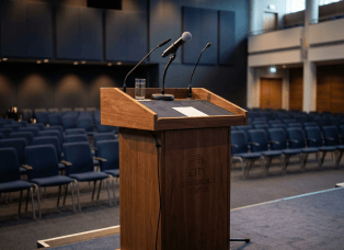 Wooden City Conference Center podium with microphones in an empty auditorium